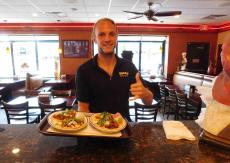 Friendly manager serving tacos at Brandy's Gyros in Hanover Park