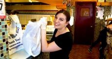 Friendly staff with carryout order at Charcoal Flame Grill in Morton Grove