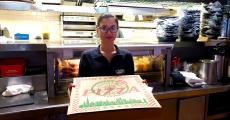 Friendly server with pizza at Chaser's Sports Bar & Grill in Niles
