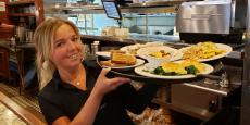 Friendly server with breakfast items at Burnt Toast Restaurant in Algonquin