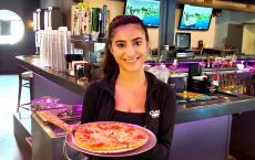 Friendly server with pizza at Chaser's Sports Bar & Grill in Schiller Park