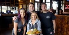 Friendly staff with nachos at Niko's Tavern in Elgin